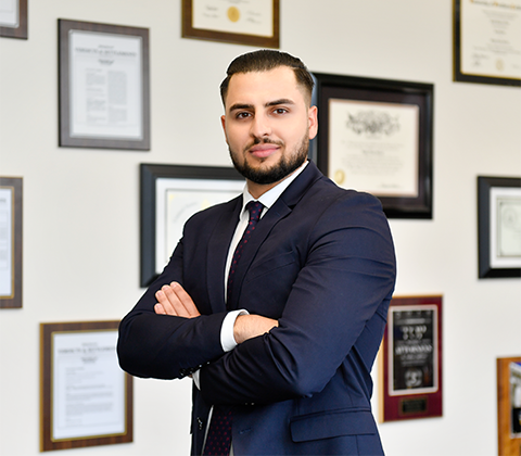 Equate Law Firm attorney in front of a wall of awords.